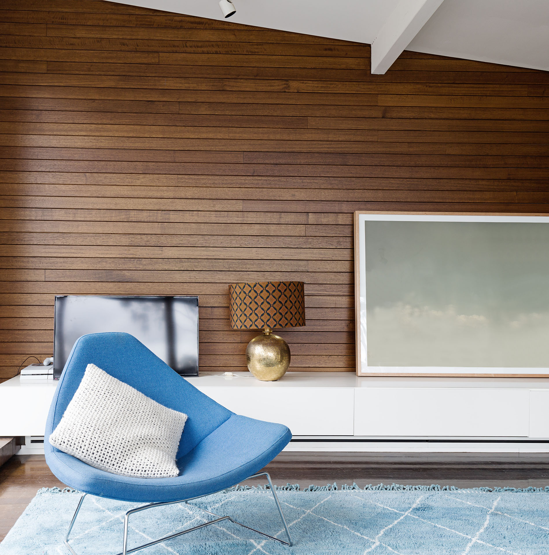 Horizontal wood panelling and blue occasional chair in mid century modern living room