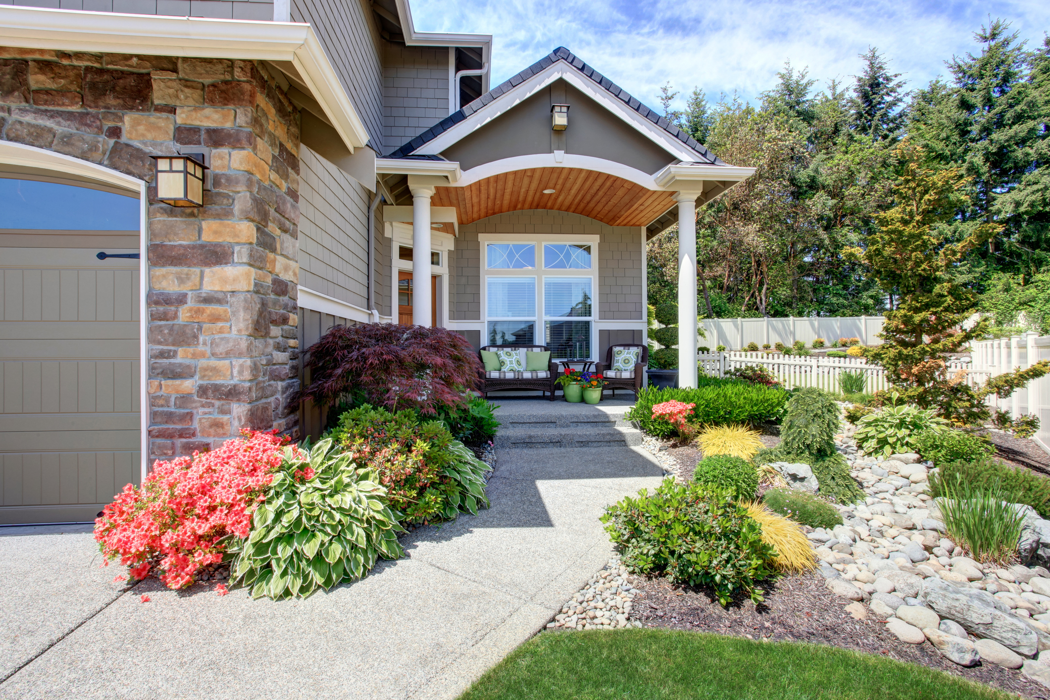 Home exterior with garage and driveway, patio area with nice landscaping desing around